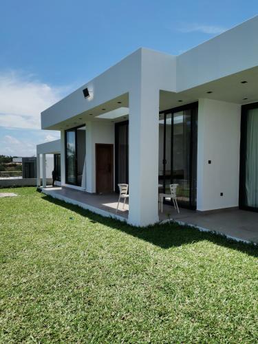 Gueima的住宿－Dzixile，草坪上带两把椅子的白色房子