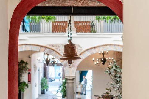 an archway with a bell hanging from a building at HOTEL BOUTIQUE CASONA 65 in Puebla