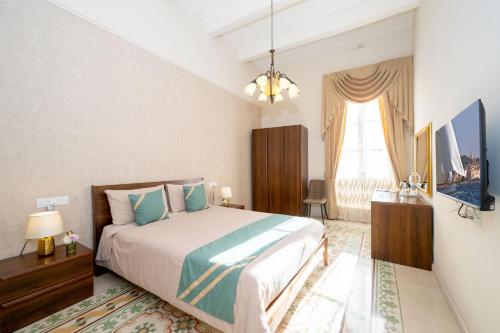 a bedroom with a bed and a television in it at Ta' Dun Martin and taz-Zija Bed and Breakfast in Nadur