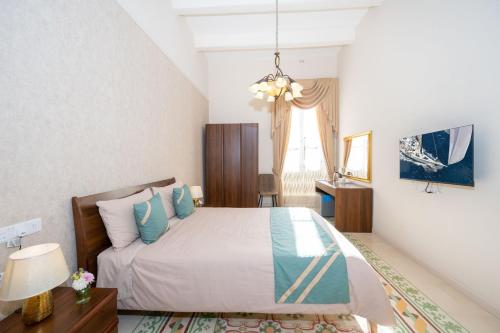 a bedroom with a bed and a desk and a window at Ta' Dun Martin and taz-Zija Bed and Breakfast in Nadur