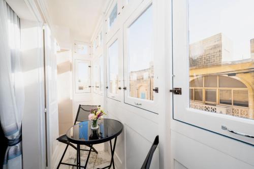 a small table in a hallway with a glass table at Ta' Dun Martin and taz-Zija Bed and Breakfast in Nadur