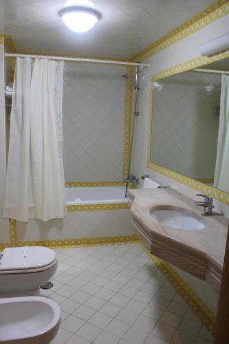 a bathroom with a toilet and a sink and a shower at Hotel Francis in Beja