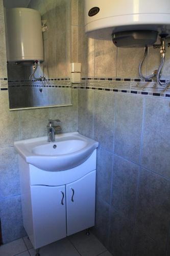 a bathroom with a white sink and a mirror at 4M Apartments in Petrovac na Moru