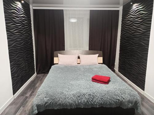 a bedroom with a bed with a red pillow on it at Квартира с WiFi и видом на город и р Днепр in Kamianske