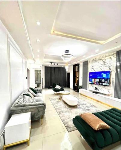a living room with two couches and a tv at Luxurious 2 bedroom Apartment with Private Chef in Lagos