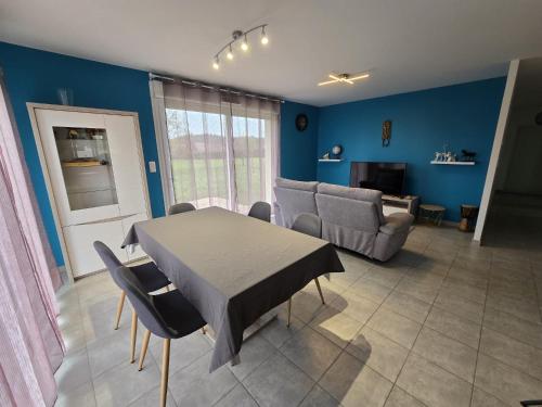 a living room with a table and a couch at Maison de la forêt in Dole