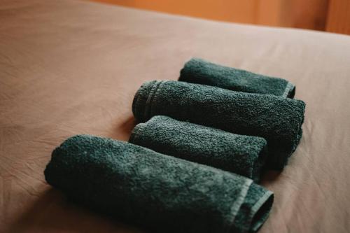 three green towels sitting on top of a bed at Ultimate Comfort ! Jacuzzi & Sauna. in Besançon