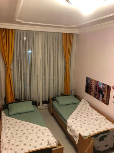 2 camas en una habitación pequeña con ventana en Erdemli/Mersin 2+1 Deniz kenarı Eşyalı Daire, en Erdemli
