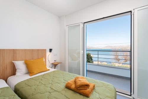 a bedroom with a bed and a balcony with a view at S'Embat sea views in Alcudia