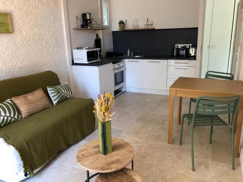 un salon avec un canapé et une table dans l'établissement La Petite Rive - Les Oliviers, à Velleron
