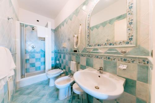 La salle de bains est pourvue d'un lavabo, de toilettes et d'un miroir. dans l'établissement Hotel Villa Giuseppina, à Scala