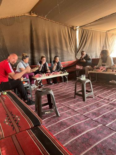 um grupo de pessoas sentadas à mesa numa tenda em Mars moon camp em Wadi Rum