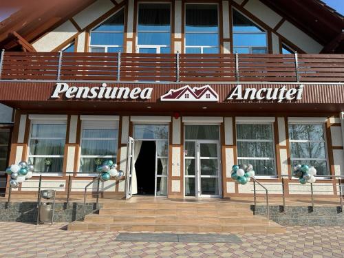 a building with a sign on the front of it at Pensiunea Ancuței in Şerpeni
