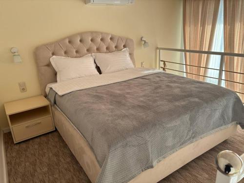 - une chambre avec un grand lit et une grande tête de lit dans l'établissement Pensiunea Ancuței, à Şerpeni