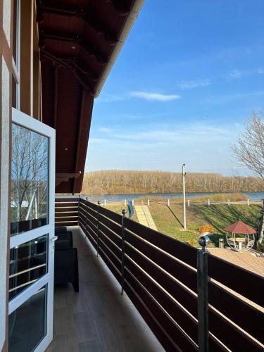 a balcony of a house with a view of a river at Pensiunea Ancuței in Şerpeni