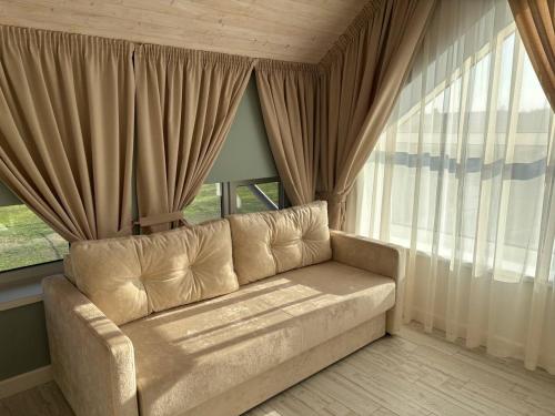 a living room with a couch in front of a window at Pensiunea Ancuței in Şerpeni