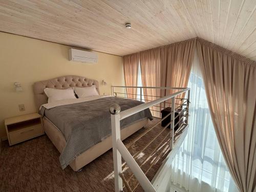 a bedroom with a bed and a large window at Pensiunea Ancuței in Şerpeni
