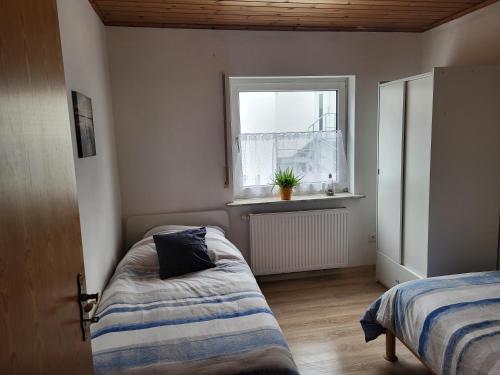 sypialnia z 2 łóżkami i oknem w obiekcie Komfortable Monteurswohnung w mieście Gutenacker