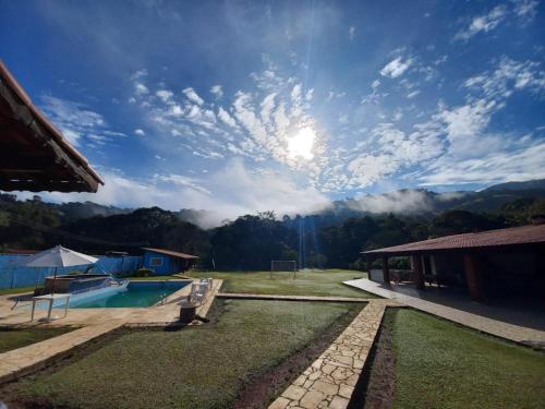 uma vista para um pátio com uma piscina e um céu em Chácara linda em Extrema em Extrema