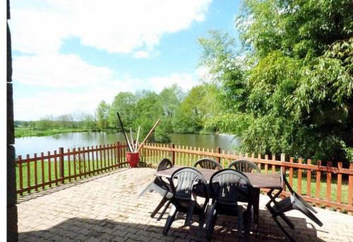 une table et des chaises avec vue sur une rivière dans l'établissement Gite Loft 3 étoiles, à Tresnay