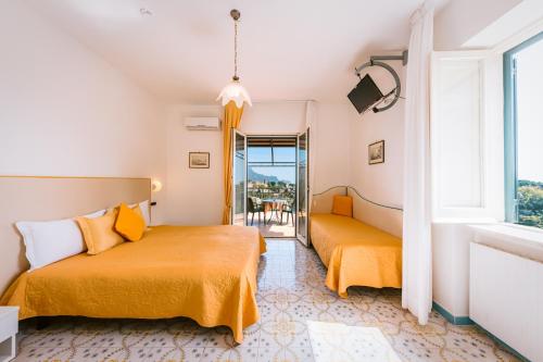 a bedroom with two beds and a balcony at Hotel Villa Giuseppina in Scala
