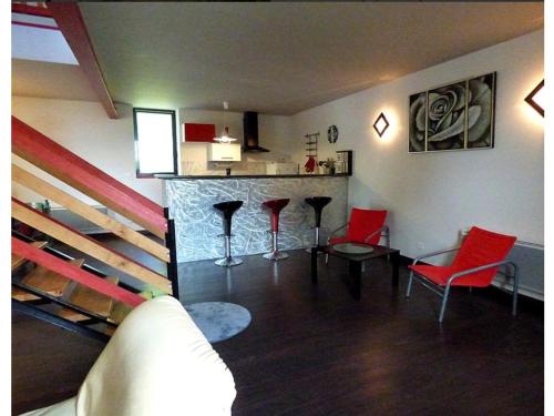 - un salon avec des chaises rouges et un bar dans l'établissement Gite Loft 3 étoiles, à Tresnay