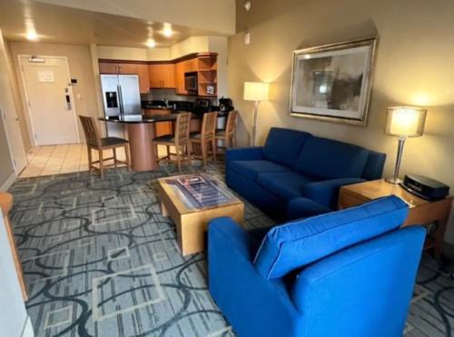 a living room with a blue couch and a kitchen at Apartment with Balcony at Platinum Hotel in Las Vegas