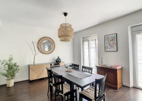 a dining room with a black table and chairs at Appartement Biarritz Saint Charles in Biarritz