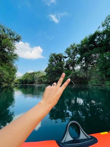 a person holding their hand up while riding a boat on a river at Rincón San Jerónimo in Tamasopo