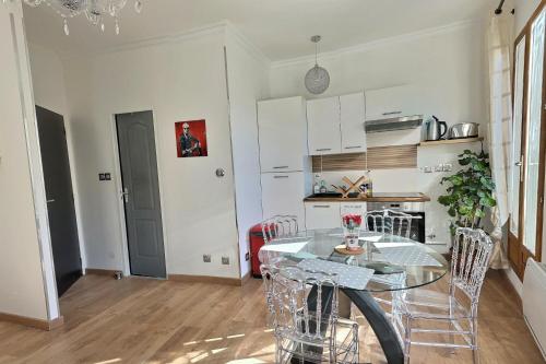 cocina con mesa y sillas en una habitación en Appartement de charme avec balcon au pied des commerces en Béziers