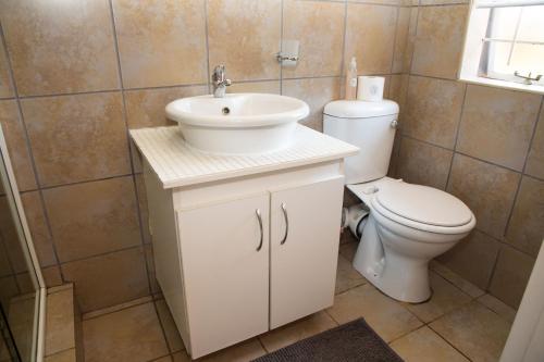 a bathroom with a white sink and a toilet at Cosy - Best Rest Potch in Potchefstroom