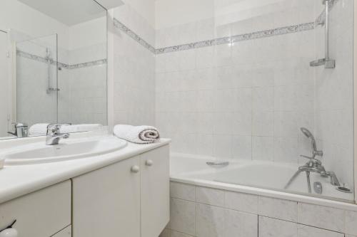 uma casa de banho branca com uma banheira e um lavatório em Studio 25m indépendant Tour Eiffel em Paris
