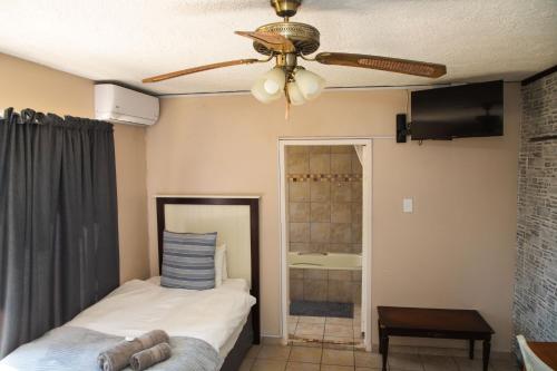 a bedroom with a bed and a ceiling fan at Cosy - Best Rest Potch in Potchefstroom