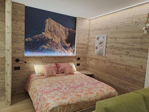 una camera da letto con un letto e un dipinto sul muro di Monolocale La Rosa a Levico Terme