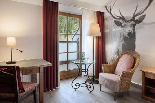 a hotel room with a deer painting on the wall at Arabella Jagdhof Resort am Fuschlsee, a Tribute Portfolio Hotel in Hof bei Salzburg