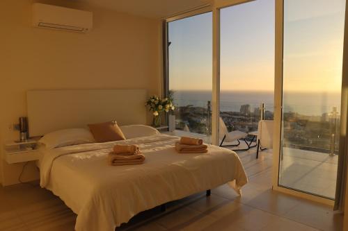 a bedroom with a bed with two towels on it at Azure Sky Villa - Panoramic ocean view, luxury, San Eugenio in Adeje