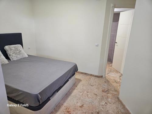 een slaapkamer met een bed en een inloopdouche bij Piso acogedor en Alcaucin in Alcaucín
