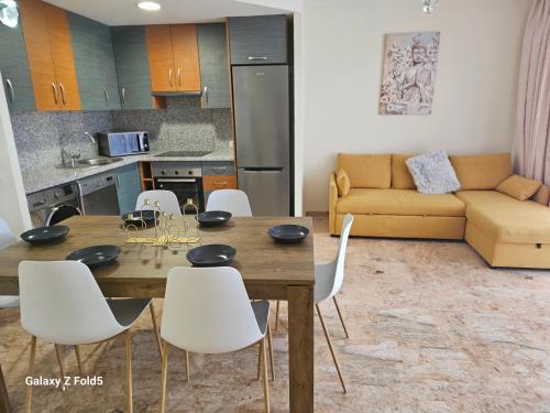 Piso acogedor en Alcaucin في ألكاوثين: مطبخ وغرفة معيشة مع طاولة وكراسي