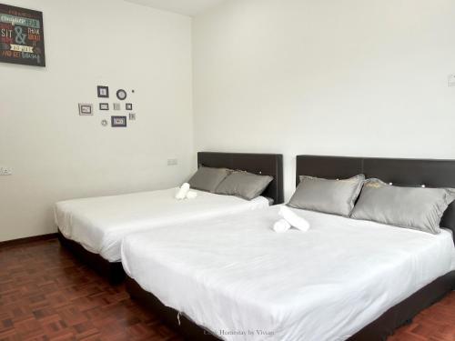 two beds sitting next to each other in a room at Ipoh Cozy Homestay for 10-13pax in Ipoh
