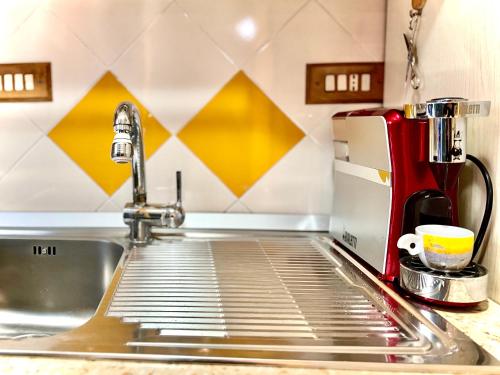 fregadero de acero inoxidable en una cocina con cafetera en Casa vacanze Hippocampus, en Salerno