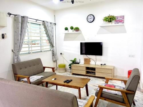 a living room with a couch and a tv at Ipoh Cozy Homestay for 10-13pax in Ipoh