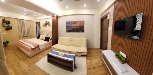 a hotel room with a bed and a television at PANTHASHALA Dooars in Lataguri