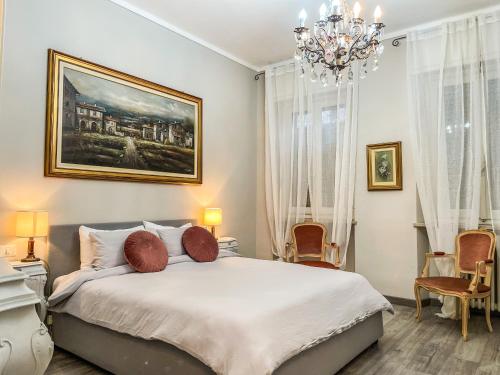 a bedroom with a large bed with a chandelier at La Casa Bianca in Vercelli