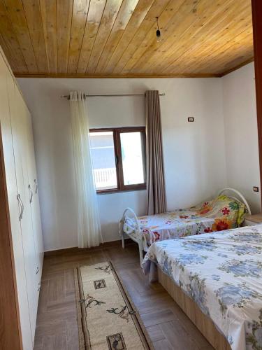 1 Schlafzimmer mit 2 Betten und einem Fenster in der Unterkunft Bert-House close to the sea in Lezha