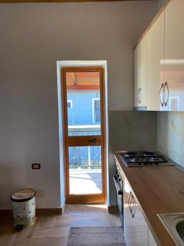 eine Küche mit einer Tür, die auf eine Terrasse führt in der Unterkunft Bert-House close to the sea in Lezha