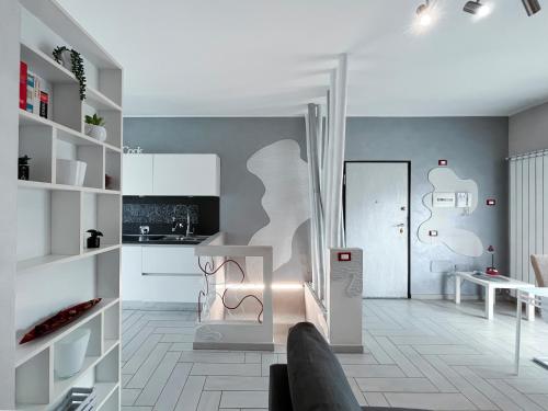 une cuisine avec des placards blancs et un salon dans l'établissement Oasi Holiday Anagnina, à Rome