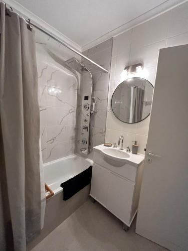 a bathroom with a sink and a tub and a mirror at AYRES DEL LEZAMA Best Apartment! Park, History and Gastronomy in Buenos Aires
