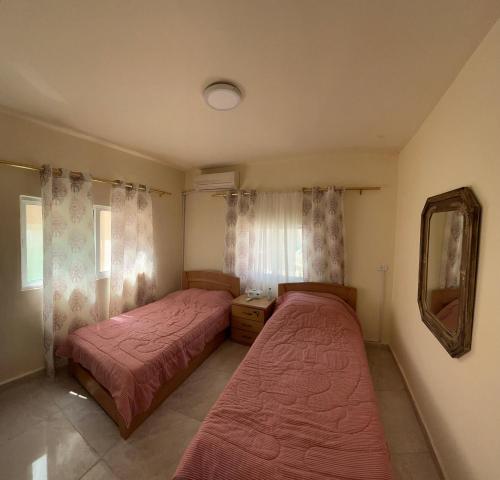 a bedroom with two beds and a mirror at Al Karak House in Kerak