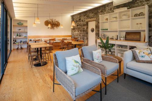 a restaurant with chairs and a table and a dining room at Carmo Country Villas in Ponta Delgada