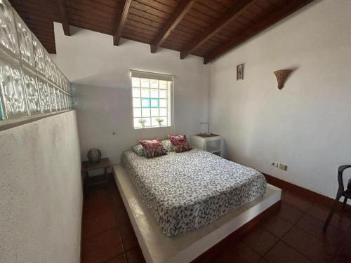 a bedroom with a bed in a room with a window at Loft near the BEACH in La Mareta